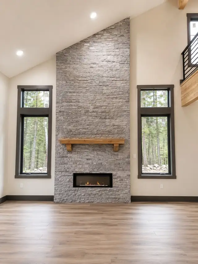 Living room remodel with floor-to-ceiling stacked stone fireplace, wood mantel and LVP flooring